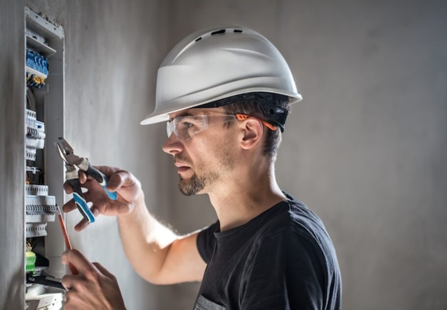man-an-electrical-technician-working-in-a-switchboard-with-fuses-installation-and-connection-of-electrical-equipment_169016-3865.jpg
